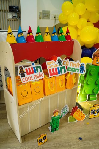 Bàn decor hộp quà, nón, chibi, và hashtag sinh nhật chủ đề Lego - bé Win